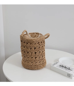 Détail du sac seau en paille tressé main avec motif ajouré et sac intérieur à cordon