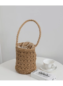 Détail du sac seau en paille ajourée avec poignée tissée et doublure à cordon