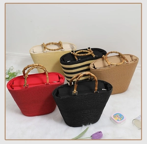 Detail view of woven straw tote bags showing bamboo handles and secure zipper closure