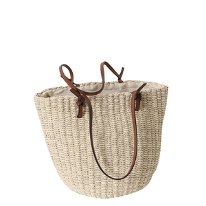 Handwoven straw bucket tote bag with brown leather handles and decorative knots
