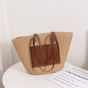 Large beige woven straw tote bag with brown leather pocket and handles for beach vacation