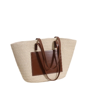 Large beige woven straw tote bag with brown leather pocket and slim shoulder straps
