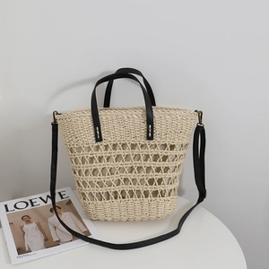 Hollow straw tote bag with black leather straps and lining for summer beach vacations