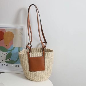 French vintage straw woven bucket bag with brown leather straps for beach holidays