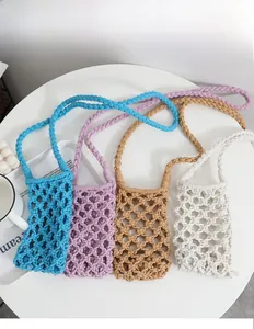Detail of colorful hollow knit shoulder bags in blue, purple, brown and white colors