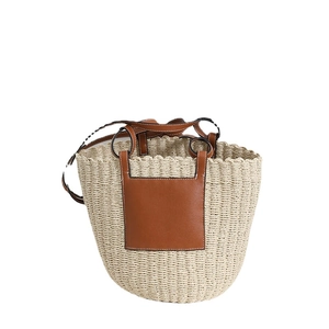 French vintage woven straw bucket bag with brown leather patch for beach vacation