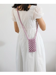 Detail of purple handmade crochet crossbody phone bag with woven shoulder strap