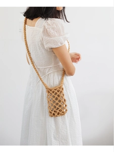 Detail of handmade crochet crossbody bag in khaki featuring a hollow mesh weave pattern