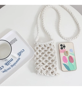 Close-up of white handmade crochet phone bag with hollow woven cotton rope patterns