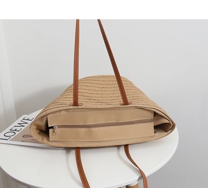 Detailed top view of straw tote bag showing smooth metal zipper and beige canvas lining