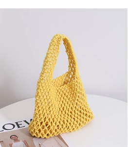 Detail of bright yellow handmade macrame woven tote bag with hollow mesh pattern