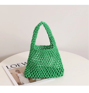 Detailed close-up of grass green hand-woven cotton rope handbag with hollow mesh texture