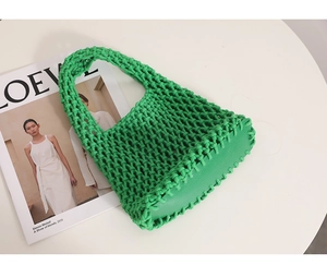 Detail view of the bright green woven cotton mesh bag on a clean minimalist surface