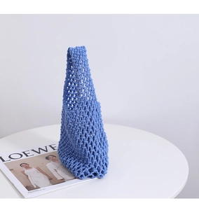 Detailed close-up of sky blue woven cotton net bag with intricate hollow knit pattern