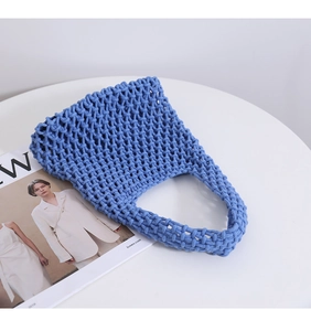Detailed close-up of sky blue hand-woven cotton net tote bag with hollow honeycomb texture