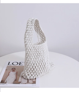 Detail of hand-woven cotton mesh texture and handle on minimalist ivory beach tote bag