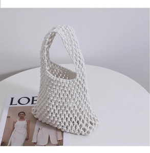 Detailed close-up of the woven hollow design on this white cotton handmade handbag
