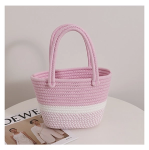 Detailed view of pink and white woven cotton tote bag with circular handles on white pedestal