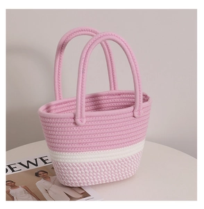 Detailed view of pink and white woven cotton bucket bag with stripe pattern on a table