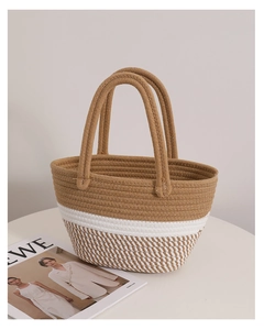 Detail view of woven cotton rope handbag in khaki and white stitching on a minimalist table