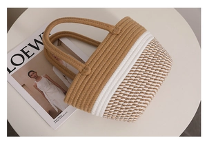 Close-up of color-block woven cotton handbag with striped texture on a white display stand