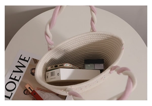 Top-down view of a woven cotton hand bag showing capacity with cosmetics and phone