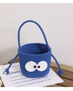 Detail of blue cotton woven bucket bag with cute cartoon big eyes and knotted handle