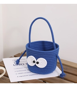 Close-up of blue woven cotton bucket bag featuring cute cartoon big eyes and rope handles