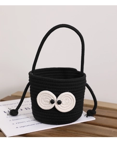 Detail of black woven cotton hand bag featuring iconic large eye crochet design and handle