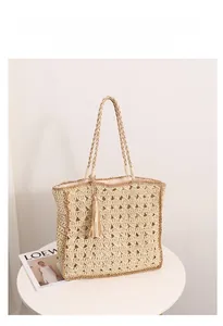 Dettaglio della trama a rombi traforata e nappa decorativa sulla borsa in paglia
