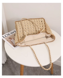 Dettaglio borsa tote in paglia intrecciata a mano con cerniera e trama a maglia