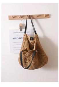 Close-up of woven straw tote bag with magnetic clasp and leather shoulder straps