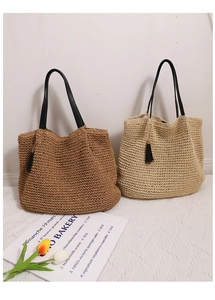 Close-up of large straw woven bags with tassel detail in coffee and beige colors