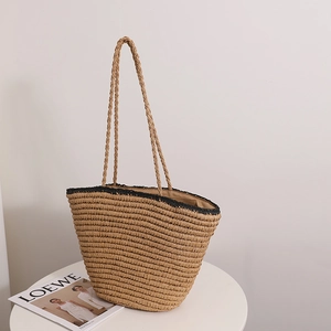 French vintage straw tote bag with black trim and long handles for summer beach vacations