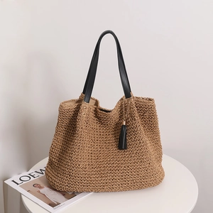 Large vintage French straw tote bag with black leather handles and tassel for beach holidays