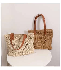 Detail of woven straw tote bags with brown leather handles and textured grid pattern