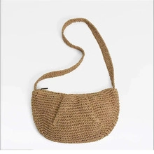 Close-up of khaki woven straw handbag showing natural texture and bamboo style design