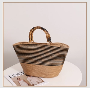 Close-up of woven straw tote bag with bamboo handles and chic black striped pattern