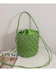Detail shot of green woven bucket bag featuring diamond texture and drawstring inner pouch