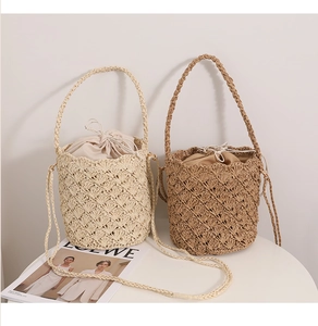 Detail of woven straw bucket bags with hollow diamond patterns and inner drawstring liners