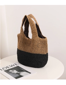 Close-up of color-block woven straw bag with integrated handle and fabric lining