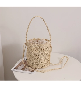 Detailed shot of bucket straw bag with intricate woven texture and inner drawstring
