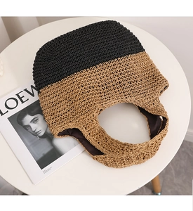 Detail of color-block straw tote showing black and beige weave with fabric lining