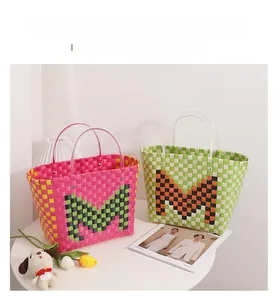 Detail of colorful woven tote bags in pink and green with transparent plastic handles