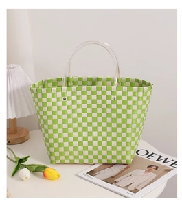 Detail of green and white checkered woven bag with transparent round resin handles