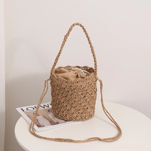 French retro straw bucket bag with hollow weave and inner drawstring for beach vacations