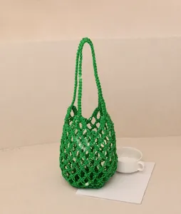 Detailed close-up of handmade bright green hollow woven net bag for beach holidays
