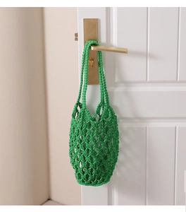 Detalle del tejido de macramé verde y nudos del bolso de playa hecho de algodón