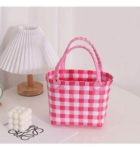 Detail der rosa-weiß karierten geflochtenen Handtasche mit strukturierten Griffen im Dekor