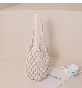 Detalle del bolso de playa de macramé hecho a mano en cuerda de algodón crema con rombos